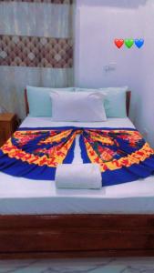 a large bed with a colorful blanket on it at DALENT RESiDENCE in Brusubi