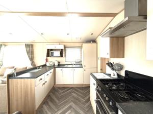 a kitchen with white cabinets and a black counter top at The Haven in Filey