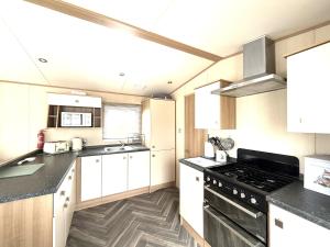 a kitchen with white cabinets and a black stove top oven at The Haven in Filey