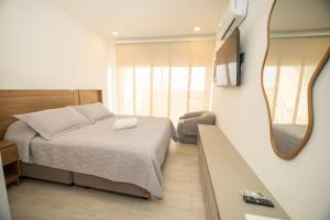 a small bedroom with a bed and a mirror at Refugio Del Mar Bello Horizonte Playa Dormida in Santa Marta +16 photos