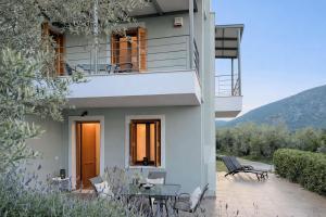 a house with a balcony and a patio at Epidavros View Villas in Ancient Epidauros