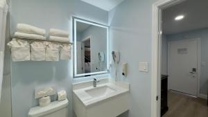 a white bathroom with a sink and a mirror at Pelican Inn in Monterey +53 photos