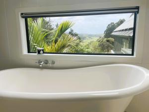 a white sink in a bathroom with a window at Matakana Retreat - Luxury Off Grid Lodge in Nature in Matakana +46 photos