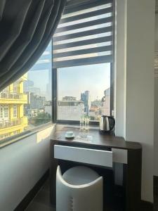a window with a desk and a chair in a room at Elegant Hotel in Hanoi