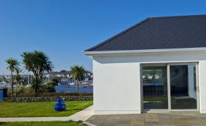 a white house with a black roof at Ferry Lodge Cottage in Kilrush