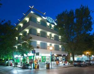 a lit up building with cars parked in front of it at Residence Sangiorgi in Cattolica