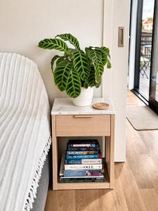 Eine Pflanze in einer Vase auf einem Tisch mit Büchern in der Unterkunft The Tiny Abode in Snells Beach