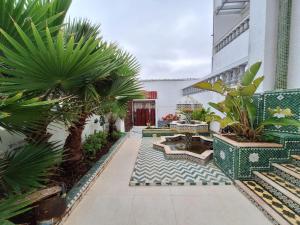 a courtyard with benches and palm trees in a building at Palace with Private Pool in Tamaris