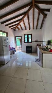 a large kitchen with white tile floors and wooden ceilings at Casa Jasmim in Marau +29 photos