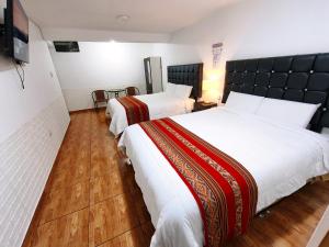 a hotel room with two beds and a television at Hostal Cusco de mis Sueños in Cusco