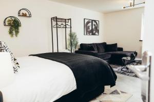 a bedroom with a black and white bed and a couch at Queensferry Collection - Residence 2 in Derby