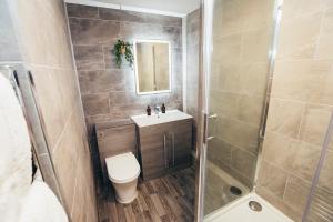 a bathroom with a shower and a toilet and a sink at Queensferry Collection - Residence 2 in Derby