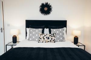 a bedroom with a black and white bed with two lamps at Queensferry Collection - Residence 2 in Derby