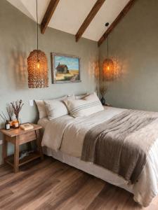 a bedroom with a large bed and a table at Boutique Cabin with Strait of Magellan Views in Punta Arenas