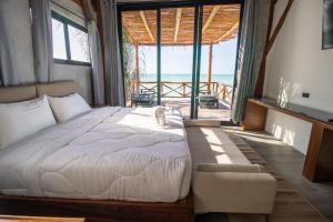 a bedroom with a bed with a cat sitting on it at Spirit Holbox in Holbox Island +183 photos