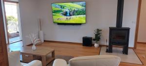 a living room with a fireplace and a tv on the wall at Valentine House in Hadspen