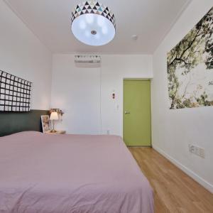 a bedroom with a large bed and a green door at Denmaru in Sokcho