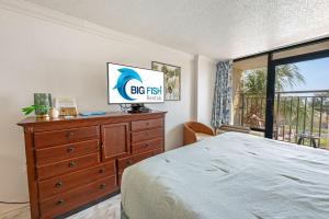 a bedroom with a bed and a dresser and a window at Amazing View Ocean Front Studio Nicely Decorated in Myrtle Beach