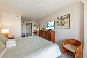 a bedroom with a bed and a tv and a chair at Amazing View Ocean Front Studio Nicely Decorated in Myrtle Beach