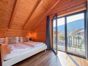 a bedroom with a bed and a large window at Rattendorf 15A in Rattendorf
