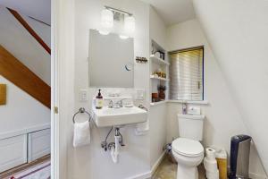 a white bathroom with a sink and a toilet at Tranquil Tides Cottage in Langley