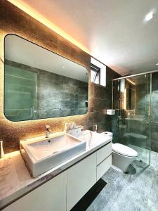 a bathroom with a sink and a toilet and a mirror at Win Home Huế in Hue