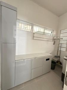 a kitchen with white cabinets and a refrigerator at Villa Shafa Marwa in Bukittinggi +18 photos