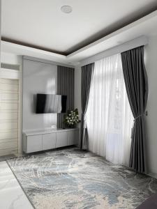 a living room with a television and a window at Villa Shafa Marwa in Bukittinggi
