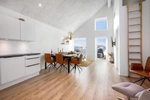 a kitchen and dining room with a table and chairs at Feriehus 1042 in Ringkøbing