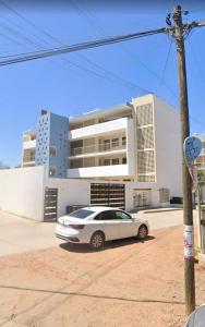 a white car parked in front of a building at Acapulco in Mazatlán