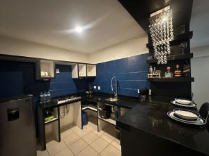 a kitchen with black counter tops and blue walls at Acapulco in Mazatlán