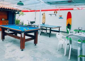 a patio with two ping pong tables and chairs at Surf & Arte Hostel in Cabo Frio +9 photos