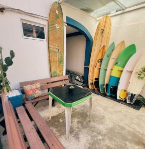 a room with a bench and surfboards leaned against a wall at Surf & Arte Hostel in Cabo Frio