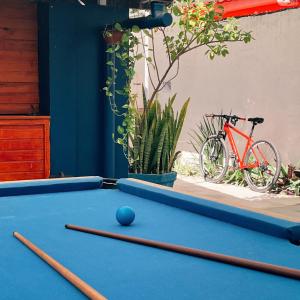 a pool table with a ball on it and a bike at Surf & Arte Hostel in Cabo Frio