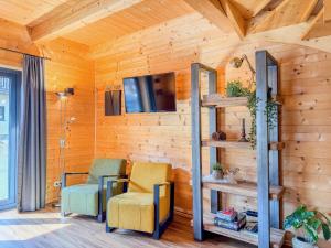 two chairs and a tv in a room with wooden walls at Rattendorf 15A in Rattendorf