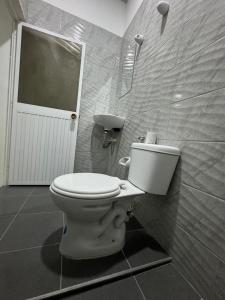 a bathroom with a white toilet in a room at HOSPEDAJE CASANOVA FlORIDA VALLE in Florida +1 photo