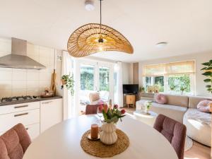 a kitchen and living room with a table and chairs at Boschalet Stijn in Hattemerbroek