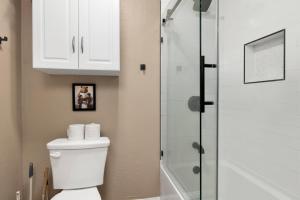 a bathroom with a toilet and a glass shower at Shiloh Woods Cabin Walk to Lake & Village Fireplace Cozy Retreat in Big Bear Lake