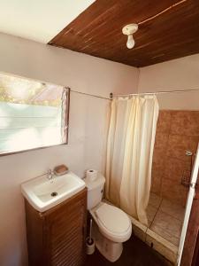 a small bathroom with a toilet and a sink at Noni garden apartment in Tamarindo
