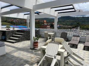 a patio with chairs and tables on a roof at Wiky House Guaduas in Guaduas