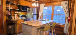 a kitchen with a counter with stools and a sink at Timber Wood, Log Cabin, Private Hot Tub, WiFi, Fireplace in Sevierville