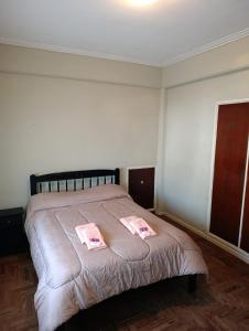 a bedroom with a bed with two pink towels on it at Sierras & Urbana in Tandil +3 photos