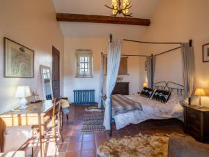 a bedroom with a canopy bed and a desk at French Villa with Pool & Games Room in Damiatte +18 photos