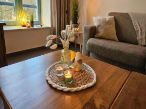 a vase with candles and flowers on a coffee table at Spacious Durbuy Apartment for 6 in Durbuy
