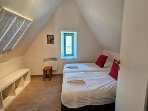 a attic bedroom with two beds and a window at Spacious Durbuy Apartment for 6 in Durbuy