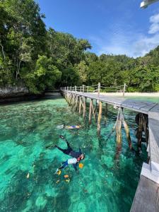 a person in the water under a bridge at Raja Ampat Eco Lodge in Tapokreng
