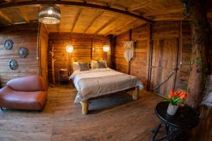 a bedroom with a bed in a wooden cabin at Refugio Natural - Guarne - Cabañas Ecológicas con Jacuzzi e hidromasaje in Guarne