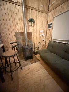 a living room with a couch and a stove at Tiny House A & M Chaiten in Chaitén