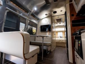 an interior of an rv with chairs and a table at Airstream Stay Private Jacuzzi & Volcano View in Monterrey +2 photos