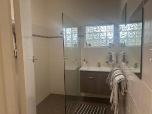 a bathroom with a glass shower and a sink at Beach Living at Its Best in McCracken +16 photos